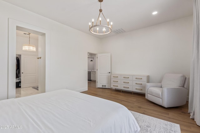 bedroom featuring a chandelier, wood finished floors, and recessed lighting