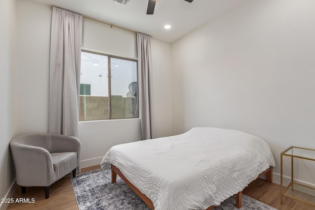 bedroom with baseboards, wood finished floors, and a ceiling fan