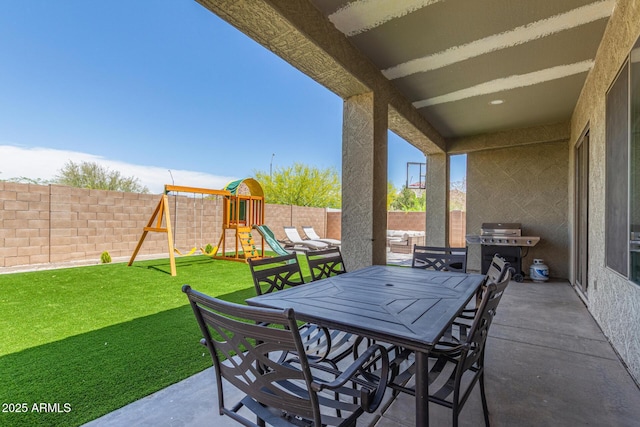 view of patio featuring outdoor dining area, a playground, and area for grilling