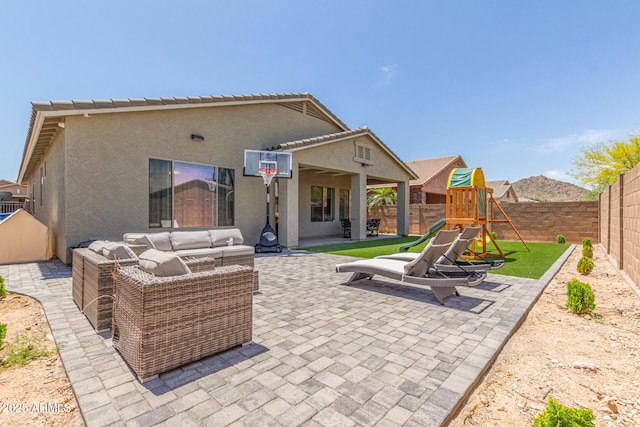 back of house with a fenced backyard, a patio, and a playground