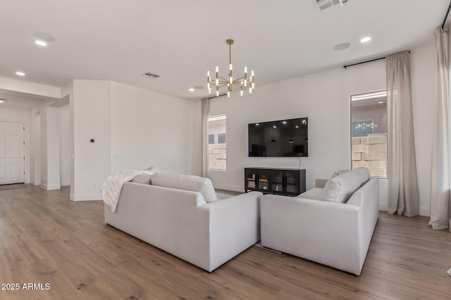 living room with light wood-type flooring, a chandelier, recessed lighting, and baseboards