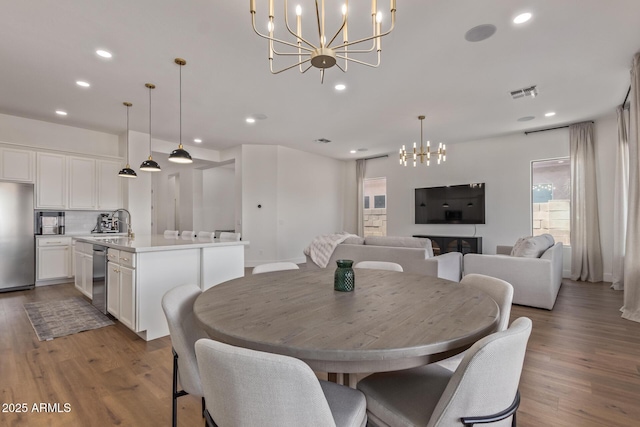 dining space with a chandelier, plenty of natural light, light wood-type flooring, and recessed lighting