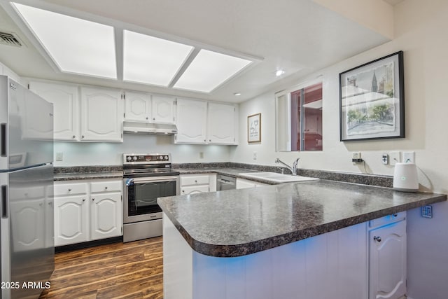 12222 N Paradise Village Pkwy S Unit 442, Phoenix, AZ 85032 - kitchen with appliances with stainless steel finishes, under cabinet range hood, a sink, a peninsula, and dark countertops