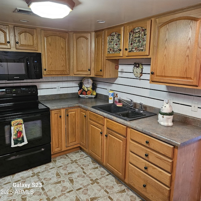 kitchen featuring tasteful backsplash, sink, and black appliances