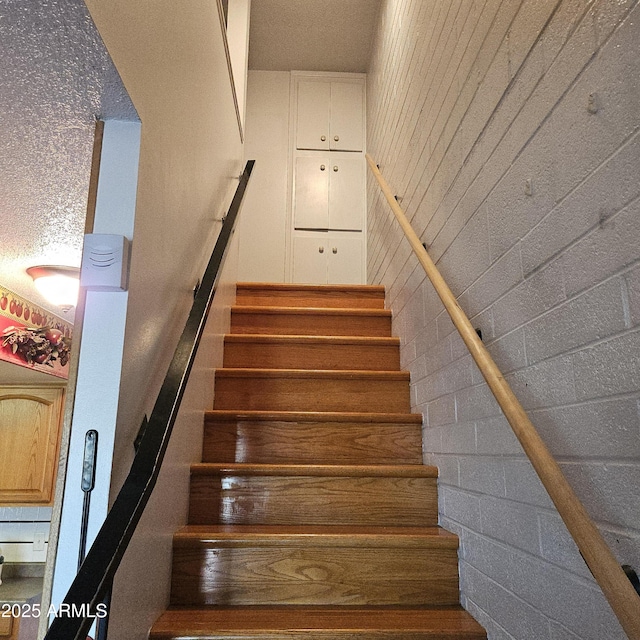 stairway featuring wooden walls