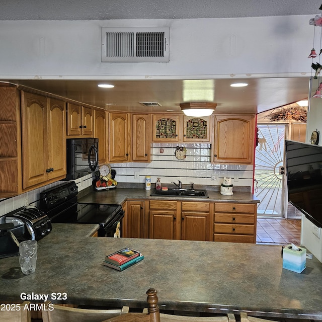 kitchen with tasteful backsplash, sink, and black appliances