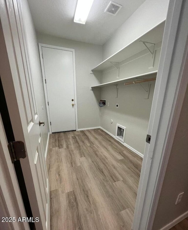 clothes washing area with washer hookup, visible vents, hookup for an electric dryer, wood finished floors, and laundry area