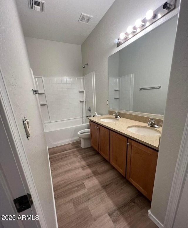 bathroom with wood finished floors, a sink, and visible vents