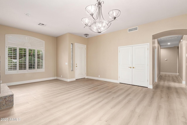 22322 N 77th St, Scottsdale, AZ 85255 - unfurnished dining area featuring arched walkways, light wood-style floors, baseboards, and a chandelier