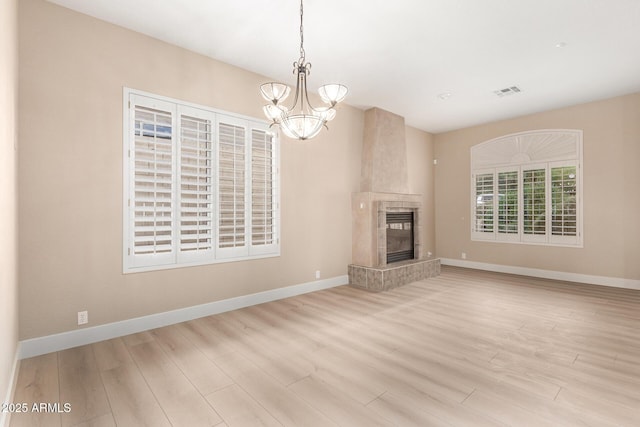 22322 N 77th St, Scottsdale, AZ 85255 - unfurnished living room with wood finished floors, baseboards, a chandelier, and a tiled fireplace