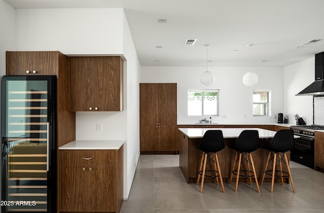 7646 E Catalina Dr, Scottsdale, AZ 85251 - kitchen with high end stainless steel range, beverage cooler, wall chimney exhaust hood, visible vents, and modern cabinets