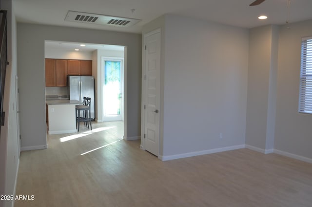 unfurnished room with light wood-type flooring, visible vents, plenty of natural light, and recessed lighting