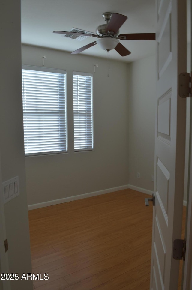 empty room with light wood-type flooring, ceiling fan, and baseboards