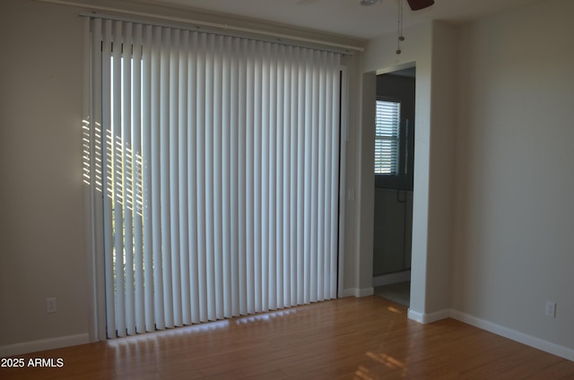 spare room featuring light wood-style floors, ceiling fan, and baseboards