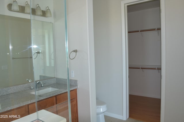 bathroom with vanity, toilet, and baseboards