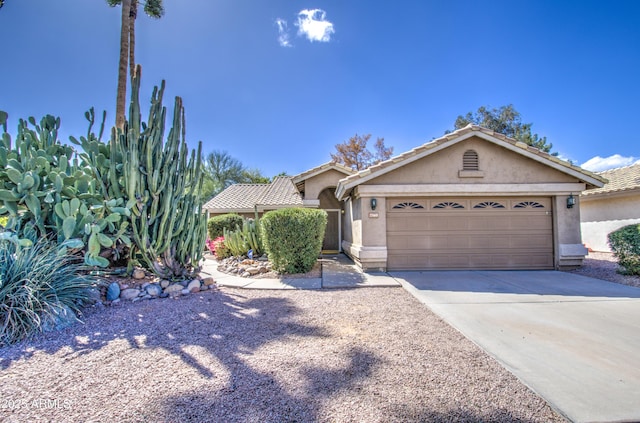 view of front of house featuring concrete driveway, an attached garage, a tile roof, and stucco siding