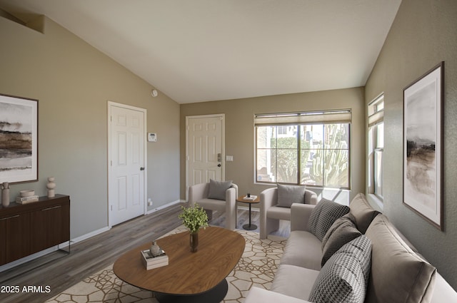 living area featuring wood finished floors, baseboards, and high vaulted ceiling