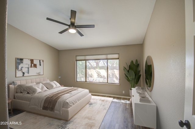 bedroom featuring a ceiling fan, lofted ceiling, and wood finished floors