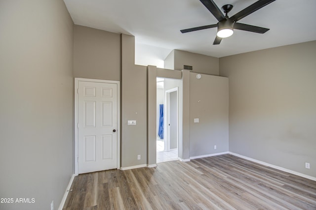 unfurnished bedroom featuring visible vents, ceiling fan, baseboards, and wood finished floors