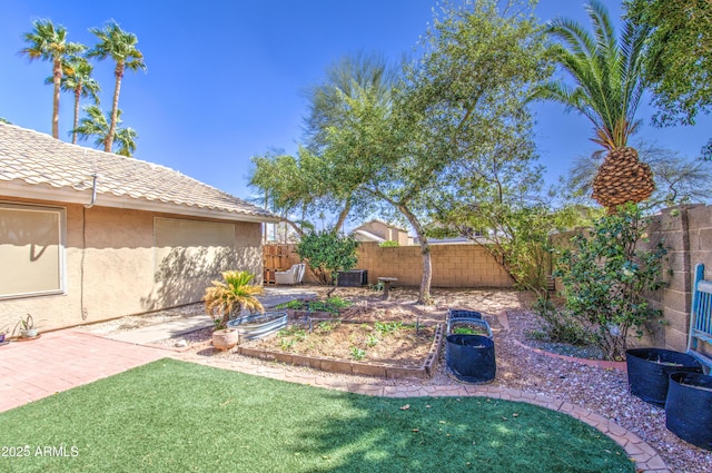 view of yard featuring a garden, a patio, and a fenced backyard