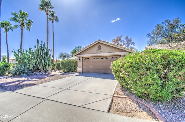 view of front of property featuring stucco siding, concrete driveway, and a tiled roof