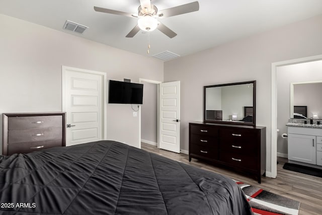 bedroom featuring baseboards, visible vents, and wood finished floors