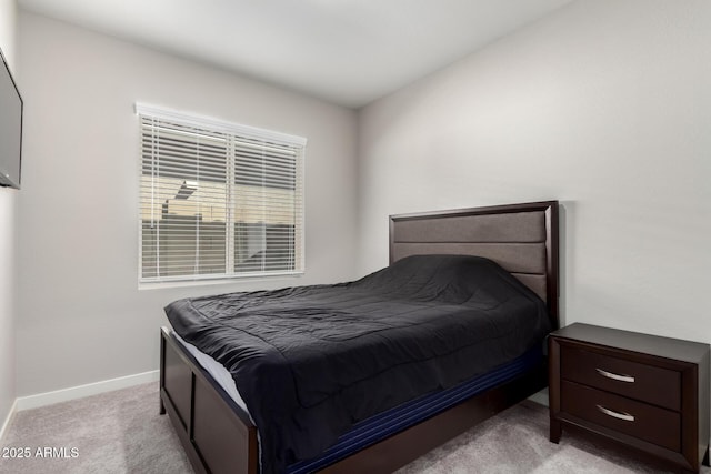 bedroom with baseboards and light colored carpet