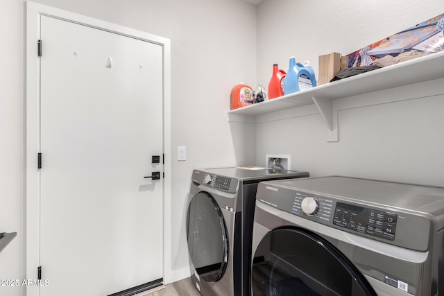 laundry room featuring laundry area, light wood finished floors, and washer and dryer