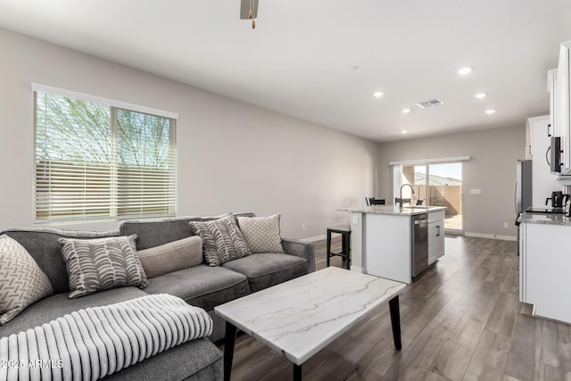 living area with baseboards, visible vents, dark wood-style flooring, and recessed lighting