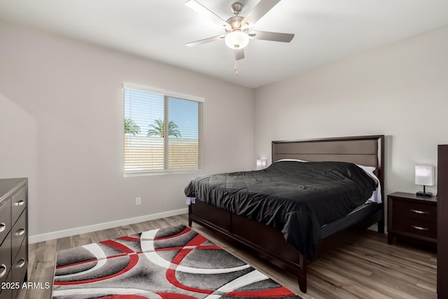 bedroom featuring light wood-style floors, baseboards, and a ceiling fan