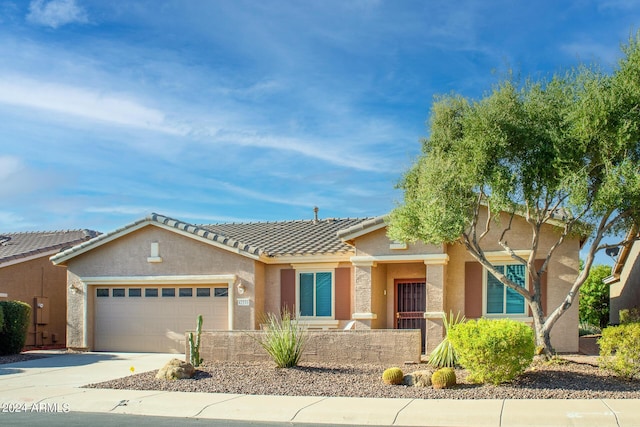 ranch-style home with an attached garage, a tile roof, concrete driveway, and stucco siding