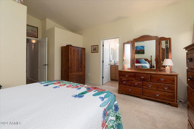 bedroom featuring light carpet and ensuite bath