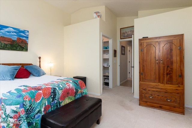 carpeted bedroom with lofted ceiling and a spacious closet