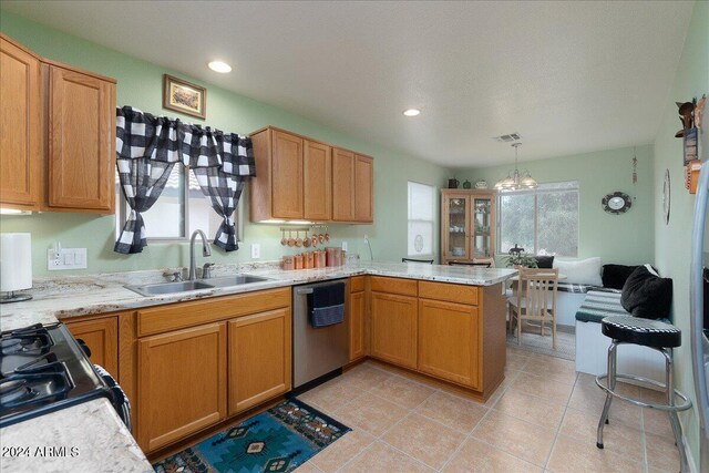 kitchen with pendant lighting, a chandelier, dishwasher, kitchen peninsula, and sink