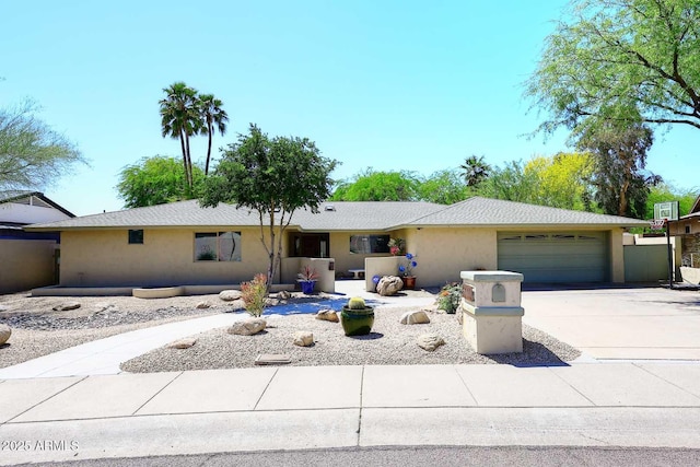 single story home with driveway, an attached garage, and stucco siding