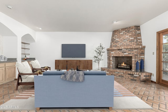 living room featuring built in shelves and a fireplace