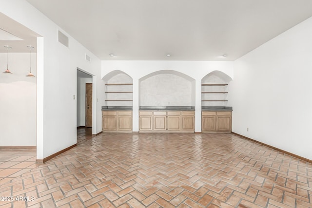 unfurnished living room featuring built in features