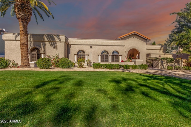 mediterranean / spanish house featuring a lawn