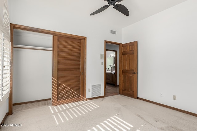 unfurnished bedroom featuring light carpet, ceiling fan, and a closet