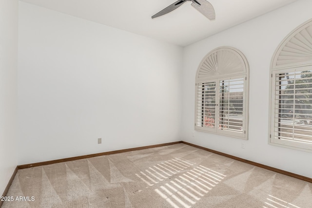 spare room with ceiling fan and light colored carpet