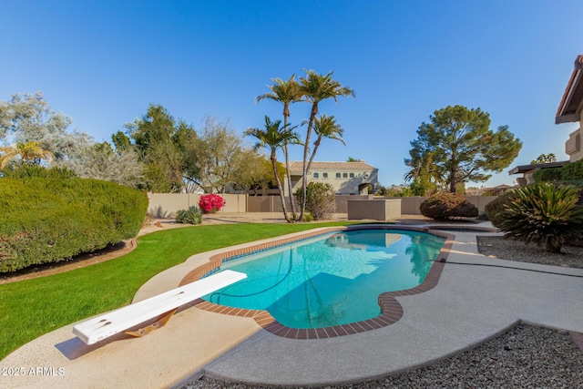 view of pool with a yard and a diving board