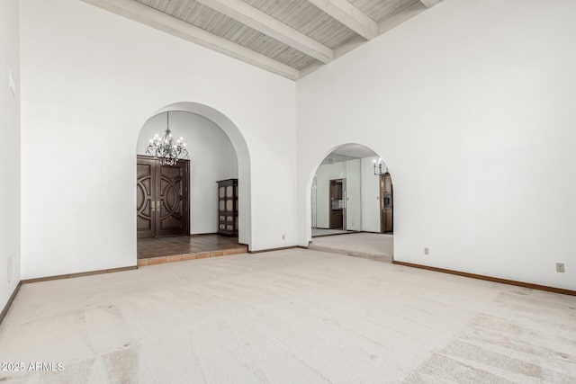 spare room with high vaulted ceiling, carpet, a notable chandelier, wooden ceiling, and beam ceiling