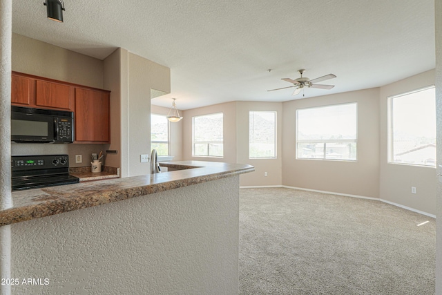 9820 N Central Ave Unit 212, Phoenix, AZ 85020 - kitchen featuring black appliances, brown cabinets, healthy amount of natural light, light colored carpet, and a textured ceiling