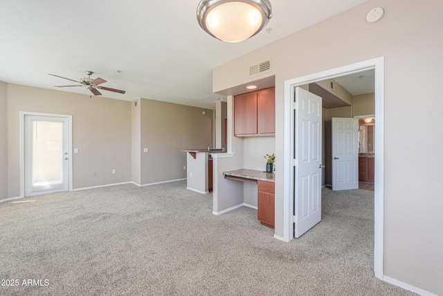 9820 N Central Ave Unit 212, Phoenix, AZ 85020 - kitchen featuring light carpet, ceiling fan, brown cabinetry, and a desk