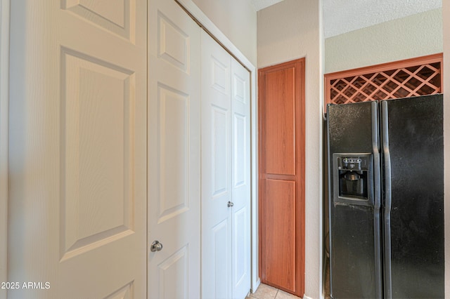 9820 N Central Ave Unit 212, Phoenix, AZ 85020 - kitchen with black fridge, light tile patterned floors, and a textured wall