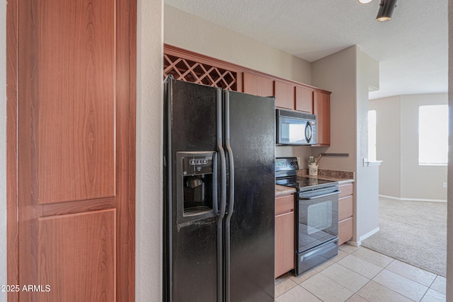 9820 N Central Ave Unit 212, Phoenix, AZ 85020 - kitchen featuring black appliances, light colored carpet, a textured ceiling, light tile patterned flooring, and brown cabinetry