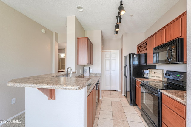 9820 N Central Ave Unit 212, Phoenix, AZ 85020 - kitchen featuring black appliances, a peninsula, a kitchen bar, light countertops, and brown cabinets