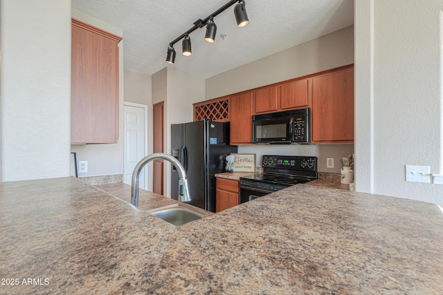 9820 N Central Ave Unit 212, Phoenix, AZ 85020 - kitchen with black appliances, brown cabinetry, a textured ceiling, rail lighting, and a peninsula