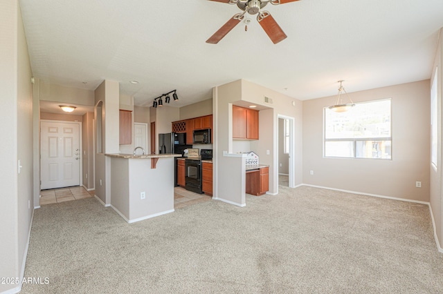 9820 N Central Ave Unit 212, Phoenix, AZ 85020 - kitchen with black appliances, brown cabinetry, open floor plan, light carpet, and ceiling fan