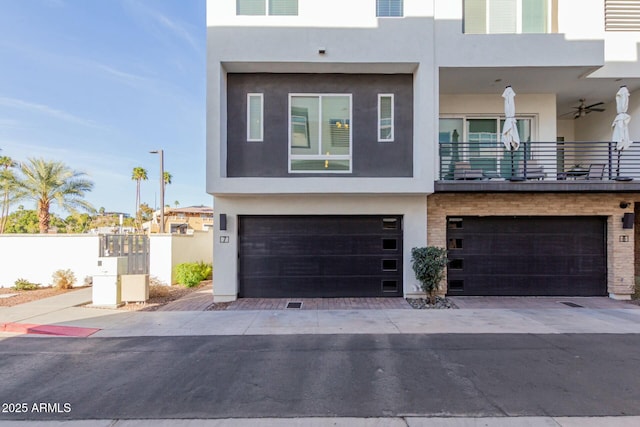 contemporary home featuring an attached garage, a balcony, and stucco siding